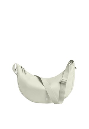 Sac à épaule beige clair en forme de croissant avec bandoulière réglable et fermeture à glissière, affichant un petit logo "GOT BAG" près du centre inférieur.