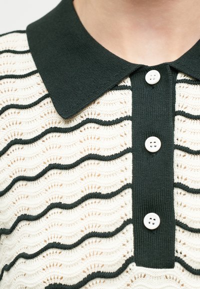 Μαύρο πουκάμισο με γιακά και λευκά κουμπιά, με κρεμ ύφασμα που έχει μαύρες κυματιστές οριζόντιες ρίγες και υφασμένο υφή.