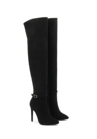 Botas negras de gamuza por encima de la rodilla, con puntera afilada, tacón de aguja y una correa decorativa con un cinturón en tono dorado.