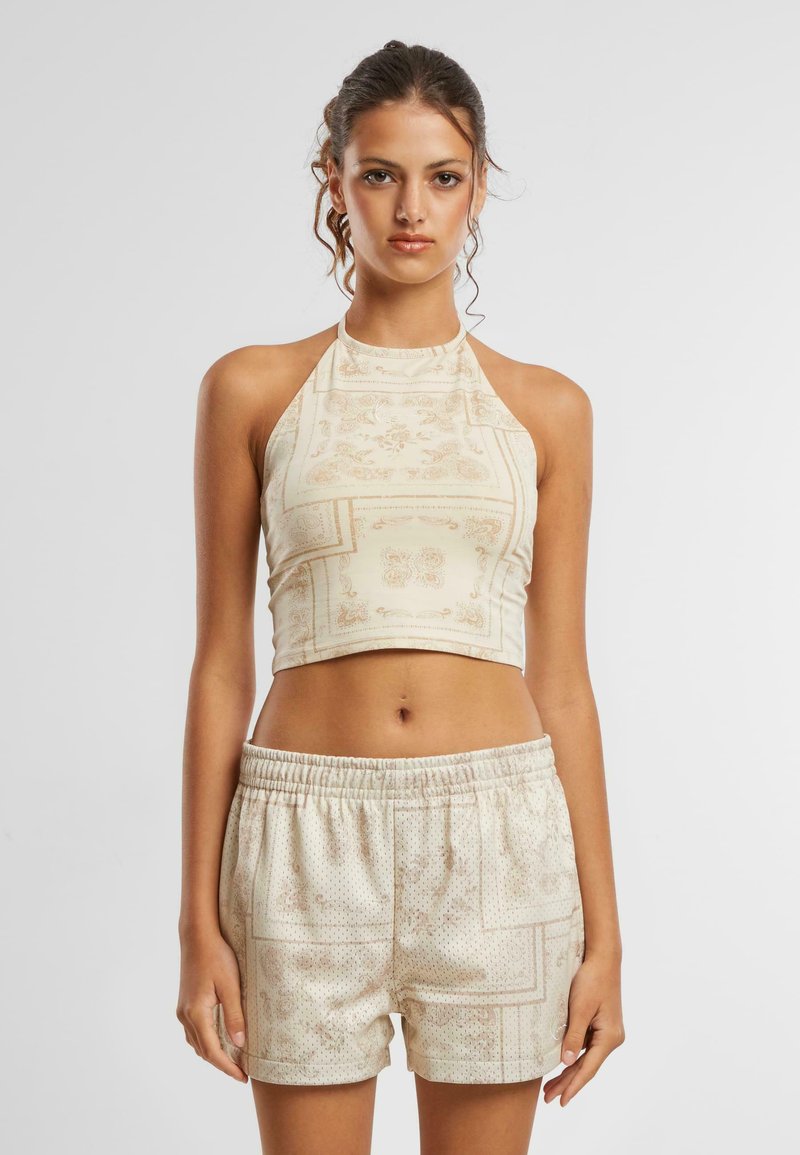 Halteri kaelusega lühike topp ja elastse vöökohtadega lühikesed püksid kreemikas värvitoonis, millel on detailne lilleline muster. Pehme kangas, millel on veidi läikiv viimistlus.