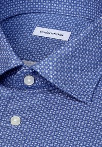 Chemise à motifs bleus avec boutons blancs et étiquette de marque Seidensticker à l'intérieur du col.