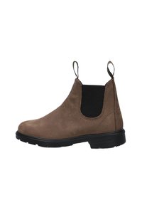 Bottette cheville en daim marron avec panneaux latéraux élastiques, languettes de traction et semelle en caoutchouc noire. Texture lisse avec des détails de couture minimaux.