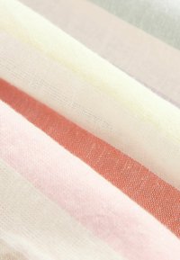 Tissu en coton doux avec des rayures horizontales de couleurs pastel en crème, rose, corail et gris clair, montrant une texture tissée en gros plan.