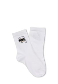 Calzini bianchi in cotone con un volto di cartone nero e beige che indossa occhiali da sole e ha un'acconciatura bianca. Lunghezza standard alla caviglia, texture liscia.