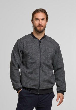 Graue, strukturierte Bomberjacke mit einem glatten schwarzen Kragen und Reißverschluss. Merkmale einen entspannten Schnitt und gerippte Bündchen, die für Komfort sorgen.