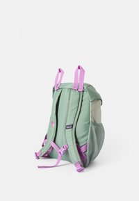 Mochila verde com alças e detalhes em rosa, apresentando bolsos laterais em malha e um compartimento principal, feita de tecido durável.