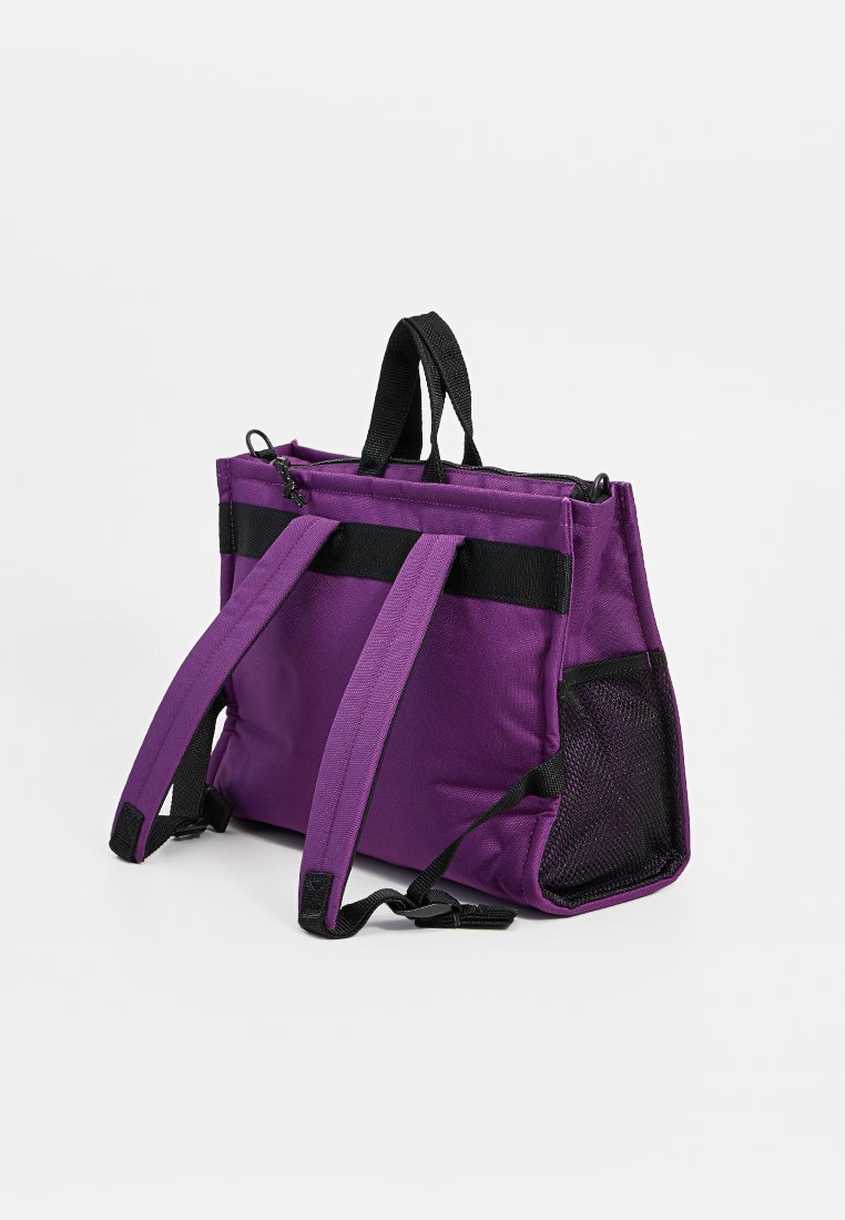 Borsa a tracolla in tessuto viola con due manici neri, chiusura con zip e tasche laterali in rete. Presenta una base rettangolare e un design strutturato.