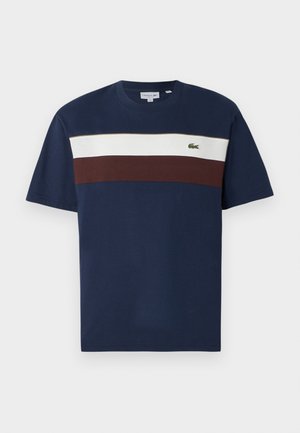 T-shirt in cotone blu navy con strisce orizzontali crema e bordeaux, dotato di un piccolo logo di un coccodrillo verde sul petto.