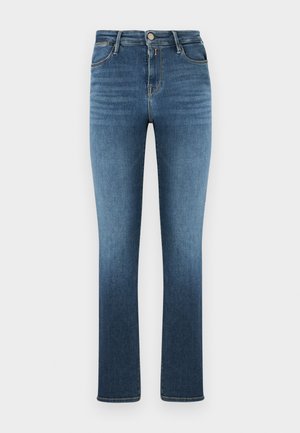 Vidutinio aukščio lieknos mėlynos spalvos džinsai iš džinso audinio su penkiomis kišenėmis ir sagos užsegimu, subtiliai išblukę šlaunų ir apatinių kojų srityse.