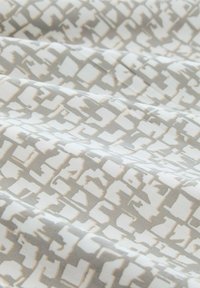 Gewebter Stoff mit einem geometrischen Muster in Grau- und Cremetönen, einer glatten Textur und einer gedämpften Farbpalette.