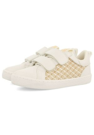 Zapatillas de cuero blancas con paneles laterales tejidos en beige, que cuentan con dos tiras de velcro y una suela de goma texturizada.