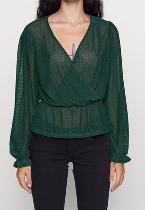 Groene doorschijnende blouse met een overslagontwerp, textuur met polka dots, lange mouwen met elastische manchetten en een aangesloten taille.
