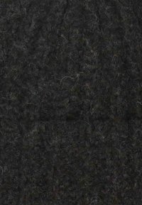 Tessuto nero con texture, densamente tessuto con una superficie pelosa, presenta leggere variazioni di ombreggiatura e fibre di luce sparse.