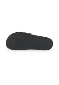 Black rubber sandal sole with zigzag and diamond tread patterns, featuring a small embossed jumping cat logo near the arch area.