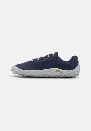 Lavprofils mørkeblå sneaker med hvide snørebånd og tekstureret grå Vibram-sål, vist fra ydersiden på en ensfarvet baggrund.