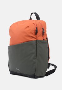 Oranje en olijfgroene rugzak met een gladde textuur, voorzien van dubbele ritsen, gevoerde schouderbanden en een rechthoekig ontwerp.