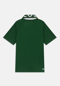 Polo shirt à manches courtes vert foncé avec un col côtelé, orné de texte blanc et d'un petit logo "Ultra Dry" près de l'ourlet inférieur.