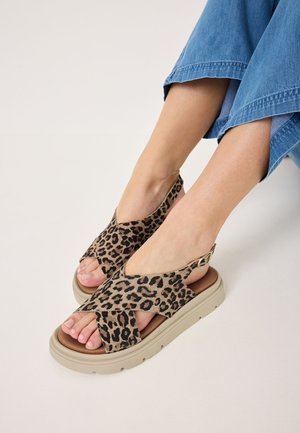 Sandali con stampa leopardata e design incrociato, realizzati in morbido tessuto, con suole in platform color beige e cinturini alla caviglia regolabili.