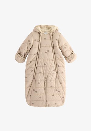 Polstrovaný béžový spací pytel s kapucí, měkkou umělou kožešinou uvnitř, dekorativními hnědými tečkovanými vzory, předním zipem a žebrovanými manžetami.