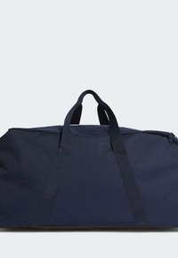 Námorní taška z odolné tkaniny, vybavená dvěma pevnými uchy, zipovým uzávěrem a prostorným designem pro všestranné využití.