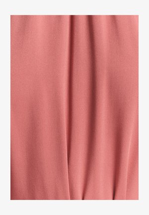 Miękka, teksturowana tkanina w jasnym odcieniu koralowym, prezentująca gładki, zwisający wygląd z delikatnym diagonalnym wzorem splotu.