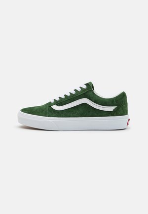Green suede sneakers with white laces and side stripe, featuring a white rubber sole and red logo at the heel. Low-top design.