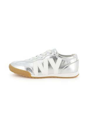 Zapatilla plateada metálica con letras blancas "NY" en el lateral y suela de goma marrón, vista desde el lado exterior.