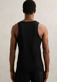 Czarny bezrękawnik z tylnym wzorem, prążkowana tekstura i okrągły dekolt. Idealny do codziennych stylizacji lub na trening.