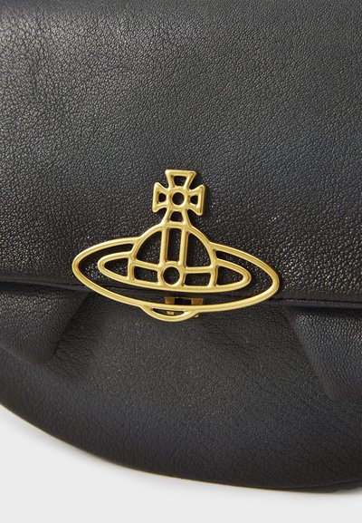 Saco de couro preto com superfície texturizada, apresentando um destacado fecho de metal dourado em forma circular, semelhante a uma nave espacial.