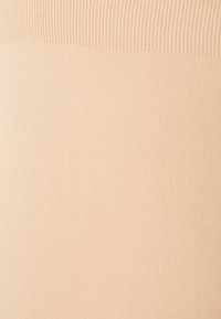 Beige, sima, rugalmas anyag ribbed derékpánttal. Puha tapintás, ideális kényelmes viselethez. Közeli nézet az anyag felületéről.