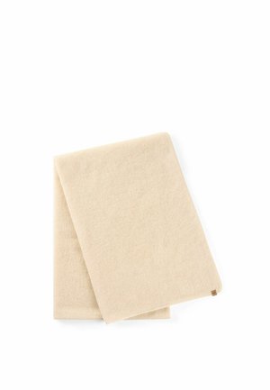 Foldet beige strikket tørklæde med lille brun mærkat på hvid baggrund.