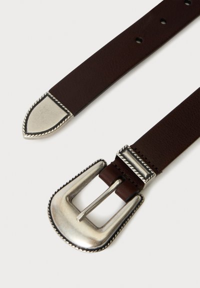 Ceinture en cuir marron avec une boucle rectangulaire argentée et une pointe argentée assortie, montrant les trous de la ceinture et des finitions détaillées sur les parties métalliques.