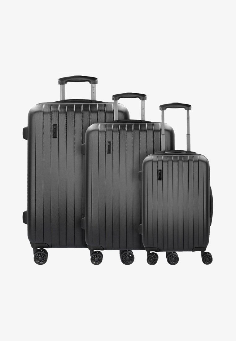 Tre valigie rigide nere di dimensioni diverse disposte insieme. Superficie texture con scanalature verticali, manici retrattili e quattro ruote ciascuna.