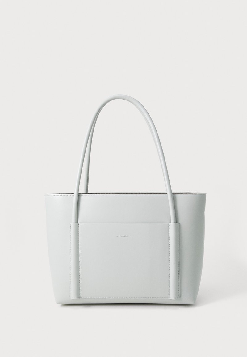 Borsa tote in pelle grigio chiaro con due manici lunghi, design strutturato e tasca frontale. Texture liscia con dettagli minimalisti.