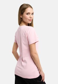 Pink cotton t-shirt featuring a round neckline and short sleeves, with a simple design and a relaxed fit, showcasing a smooth texture.