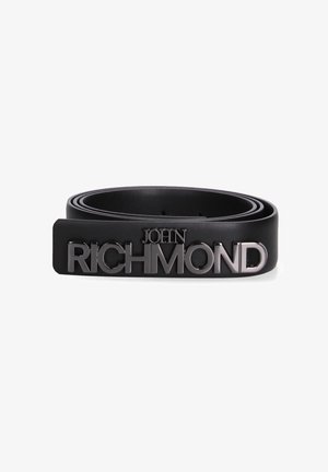 Zwarte leren riem opgerold met metalen gesp met het "John Richmond" logo in vetgedrukte, hoofdletterletters op een witte achtergrond.
