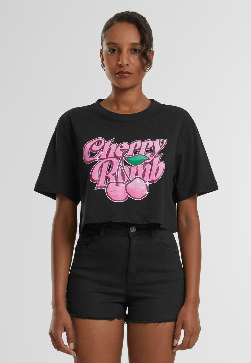 Crni skraćeni majica od pamuka s sjajnim ružičastim grafičkim prikazom "Cherry Bomb" koji sadrži trešnje i zeleni list u sredini.