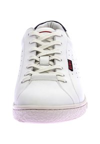 Baskets en cuir blanc avec un bout arrondi, des lacets plats, des détails perforés sur les côtés et une semelle en caoutchouc texturée. Accents noir et rouge sur la languette.