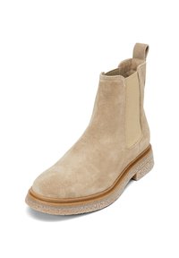 Bottine Chelsea en daim beige avec panneaux latéraux élastiques, bout arrondi et semelle plateforme texturée. Tirette à l'arrière pour un enfilage facile.