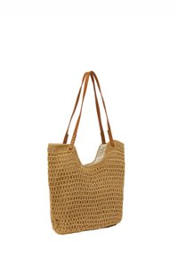 Vävd beige kasse med en texturerad, öppen väv. Har två bruna skinnaxelremmar och ett vitt tyginrede.