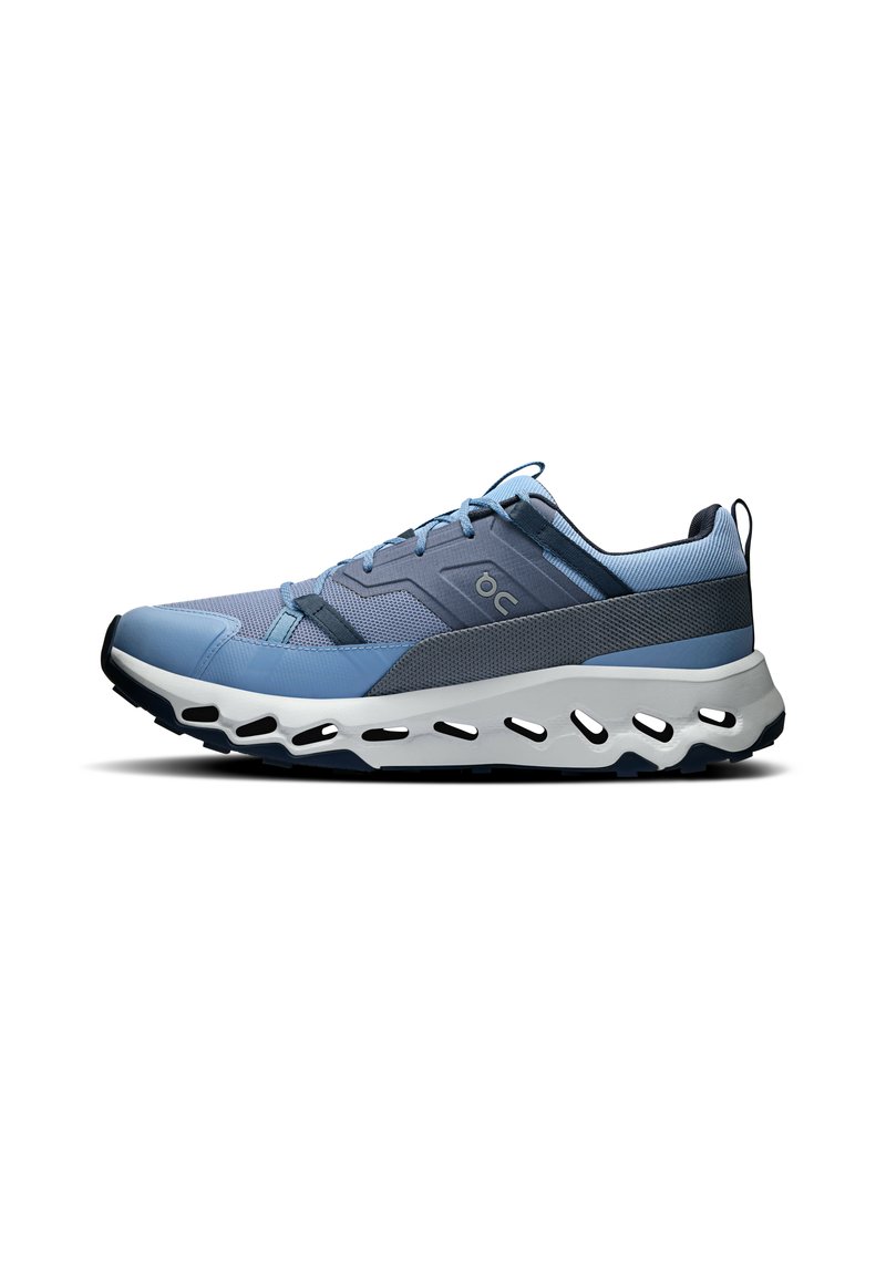 Blue athletic shoe with textured mesh upper, contrasting dark accents, thick white midsole with cutouts, and padded collar for comfort.