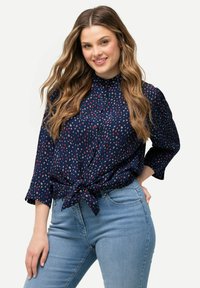 Námornická košile na knoflíky s uvazováním vpředu, s vícebarevným tečkovaným vzorem. V kombinaci s světle modrými skinny džíny. Měkká látka, 3/4 rukávy.