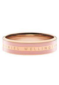 Rosa Armreif mit glatter Oberfläche, versehen mit einem goldfarbenen Metallstreifen, auf dem "DANIEL WELLINGTON" eingraviert ist. Runde Form, minimalistisches Design.