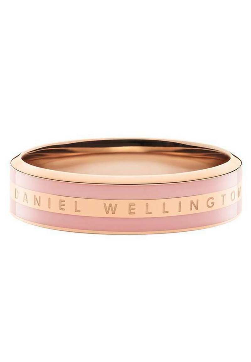 Rosa Armreif mit glatter Oberfläche, versehen mit einem goldfarbenen Metallstreifen, auf dem "DANIEL WELLINGTON" eingraviert ist. Runde Form, minimalistisches Design.