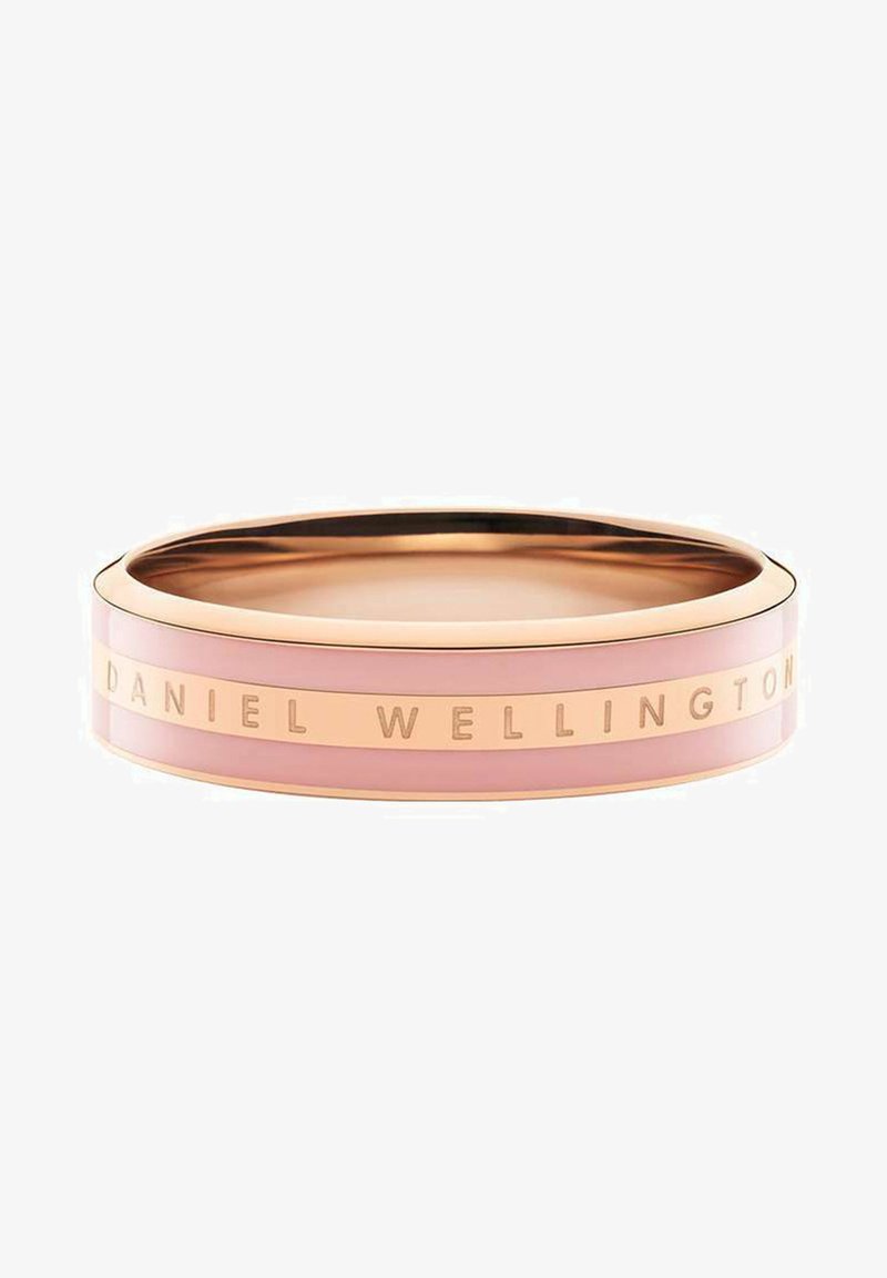 Rosa Armreif mit glatter Oberfläche, versehen mit einem goldfarbenen Metallstreifen, auf dem "DANIEL WELLINGTON" eingraviert ist. Runde Form, minimalistisches Design.
