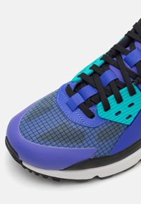 Sneaker med ett överdel i blandade material i nyanser av blått och teal, med ett rutmönster, svarta snören och texturerade accenter. Gummisula.