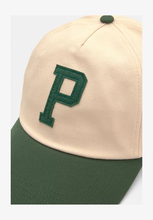 Căciulă bej cu vizieră verde și un "P" brodat verde în față. Prezintă un material structurat și o coroană rotunjită.