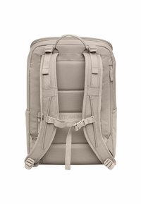 Sac à dos beige avec dos en mesh rembourré, bretelles ajustables, compartiments zippés et poches latérales pour un rangement supplémentaire.