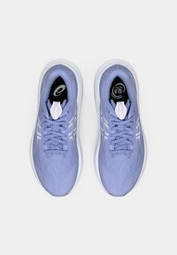 Helle lavendelfarbene Sportschuhe mit einer strukturierten Oberseite, weißen Akzenten und einer gepolsterten Sohle. Enthält Schnürsenkel, Perforationen und ein Logo auf der Zunge.