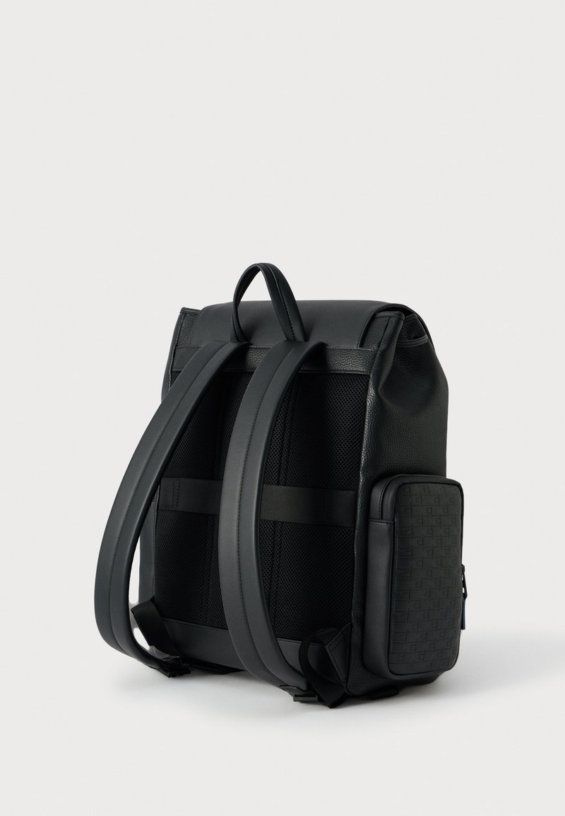 Black backpack featuring a textured material, mesh panels, wide adjustable straps, and a side zippered pocket with a patterned accent.